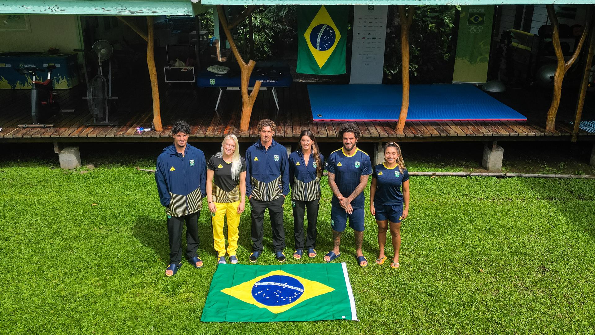 Surfistas brasileiros posam com a bandeira do Brasil