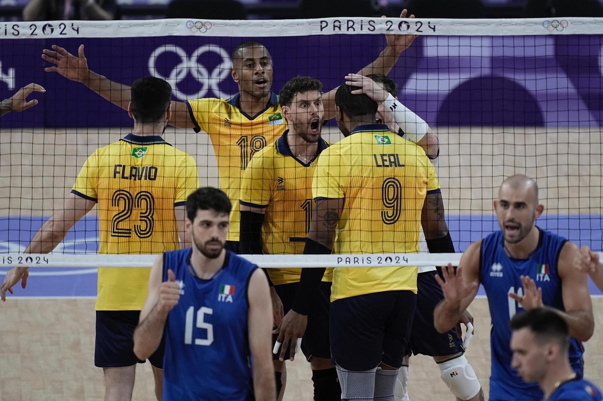 Jogadores do Brasil atrás da rede de vôlei comemoram ponto marcado